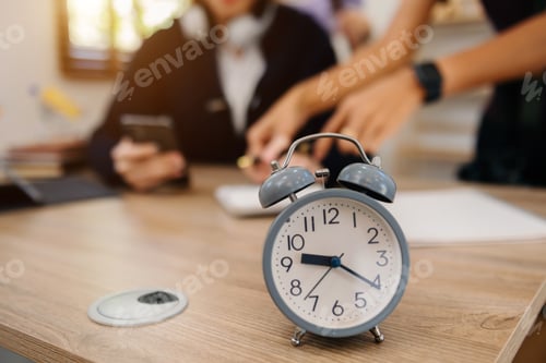 Preview: Alarm clock on the desk. Business working in modern office building or home at night using laptop.