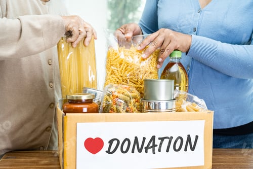 Preview: Volunteers putting various dry food in donation box for help people.