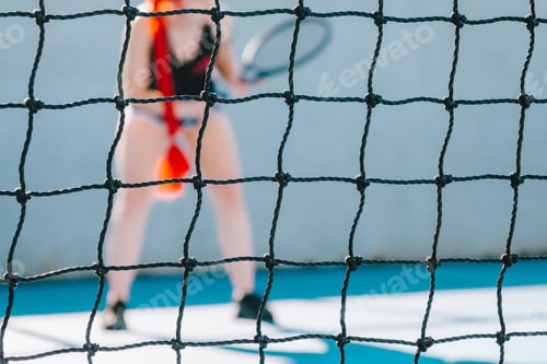 Preview: Young woman with red hair playing tennis during daytime