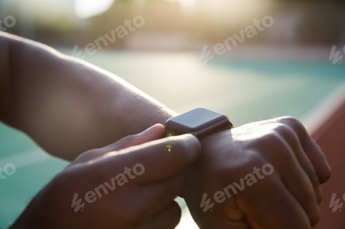 Preview: Close up of a young african sportsman adjusting smartwatch