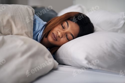 Preview: Sound asleep. Cropped shot of an attractive young woman sleeping peacefully in bed at home.