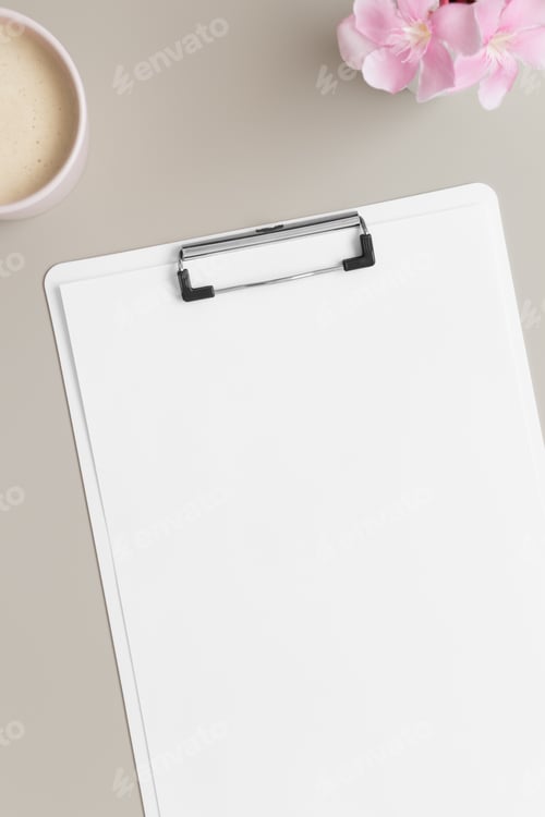 Preview: White clipboard mockup with a cup of coffee and oleander on a beige table.