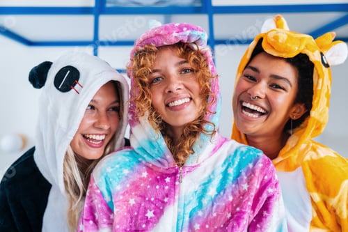 Preview: Multiethnic group of young female friends having pajamas party at home