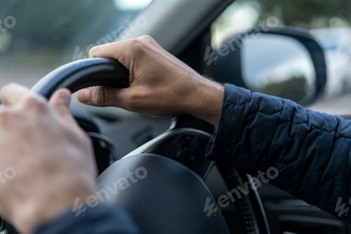 Preview: Man driving car view of steering wheel