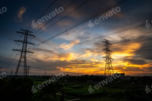 Power Lines at Colorful Sunset over a Green Field