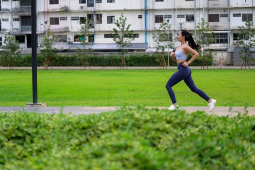 Preview: Asian woman jogging in a park, promoting a healthy and active lifestyle