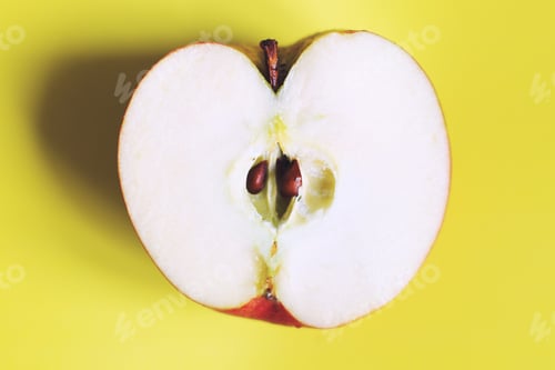 Preview: apple cut on a yellow background. half apple
