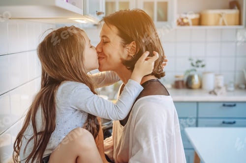 Preview: Mom kisses her little daughter in the kitchen