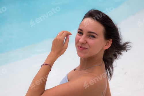 Vorschau: Porträt einer schönen brünetten Frau, die ihren Urlaub in der Nähe des Schwimmbades genießt