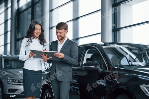 Preview: Female customer and modern stylish bearded businessman in the automobile saloon