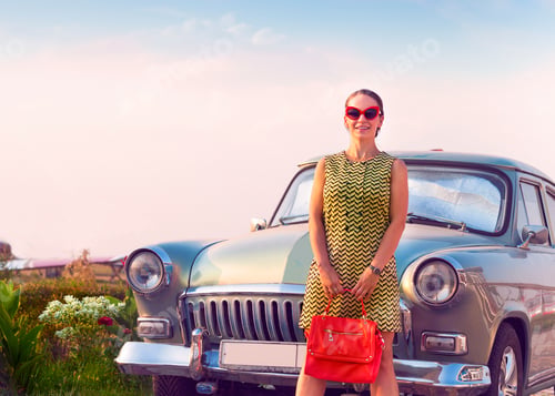 Preview: Brunette woman standing near retro car