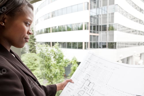Preview: A black businesswoman looking at plans for a new office