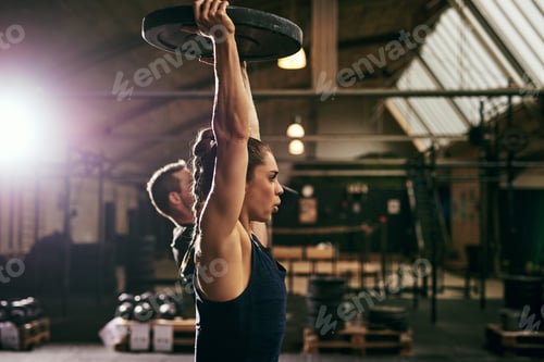 Preview: Two young sportive athletes exercising with weights