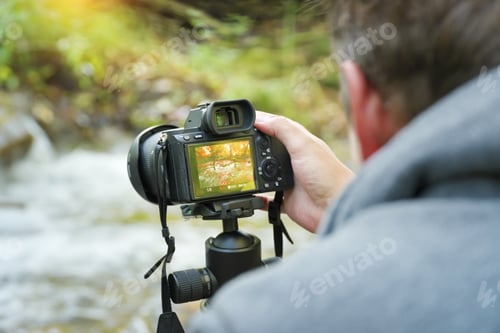 Preview: Photographer at work holding a digital camera