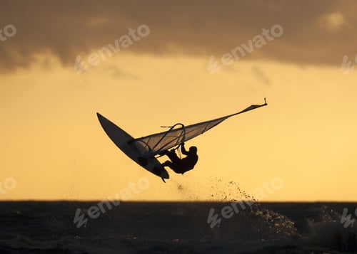 Preview: Surfer on the jump in midair with the sunset colored sky background