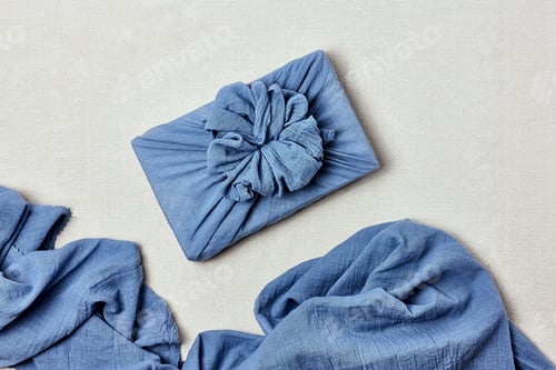 Preview: Trendy gift box wrapped in traditional Japanese furoshiki style on linen background.