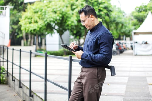 Preview: Man In Semi Formal Suit Writing on Digital Tablet