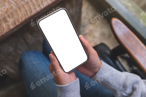 Preview: Top view mockup image of a woman using and holding mobile phone with blank screen