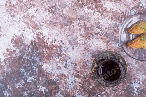Preview: A glass of tea with turkish pakhlava in glass saucer on the right side