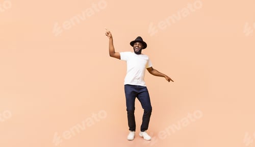 Preview: Stylish African American guy dancing over beige background