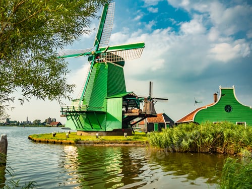 Preview: Windmills in Kinderdijk under the sunlight and a blue cloudy sky in the Netherlands