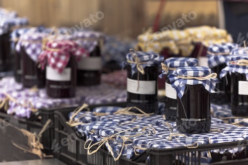Preview: Many preserving jars with dark jam in a market