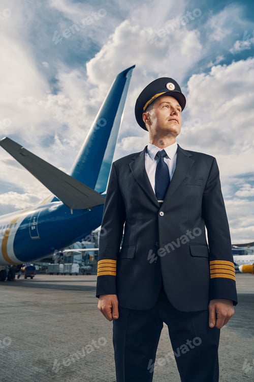 Preview: Attractive professional aviator dressed in uniform looking away