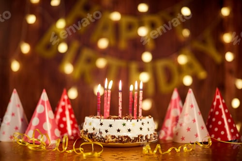 Visualização: Bolo de feliz aniversário com velas no fundo de guirlandas a