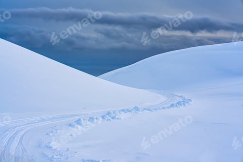 Preview: White glacier mountain with snow covered and snowmobile track on summit in winter