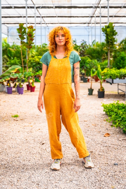 Preview: Young woman working in greenhouse surrounded by plants