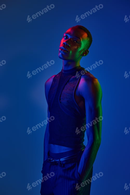 Preview: Vibrant young man showcasing stylish attire against a striking blue and green backdrop