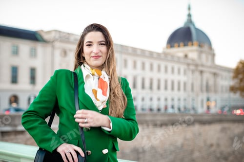 Preview: Young woman wearing green and a purse looking at camera