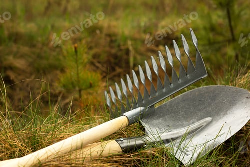 Preview: Rake and shovel is inserted into the ground for planting in the spring. Springtime, garden