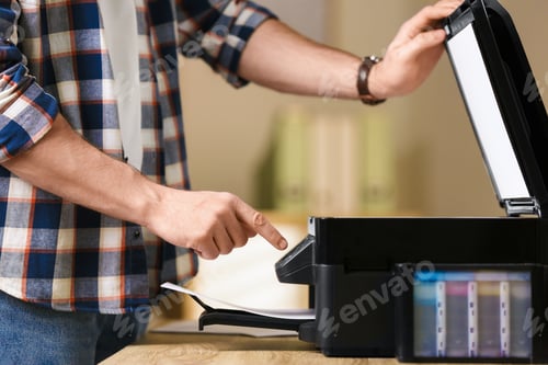 Preview: Man using modern multifunction printer in office, closeup