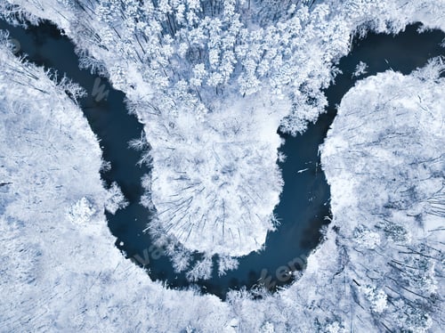 Preview: Top down view of river and snow-covered forest in winter.