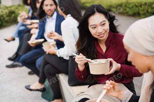 Preview: Multiethnic business people doing lunch break outdoor from office building