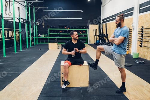 Preview: Personal trainer and man with disability enjoying conversation in gym