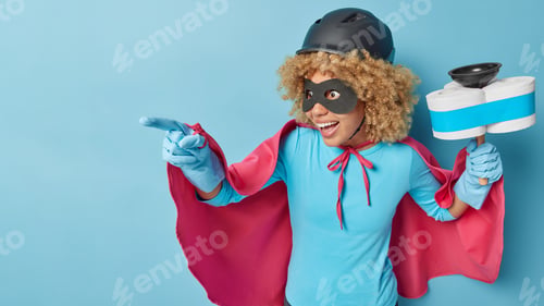 Preview: Horizontal shot of positive woman dressed in superhero costume points away into distance holds plung