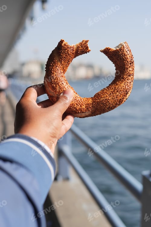 Preview: man holding a Turkish Bagel Simit against istanbul city background
