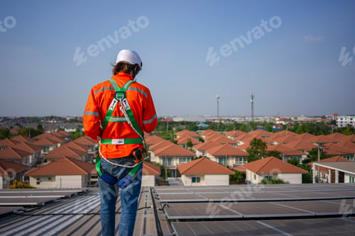 Preview: Blue collar worker is inspecting solar panel at rooftop of factory.