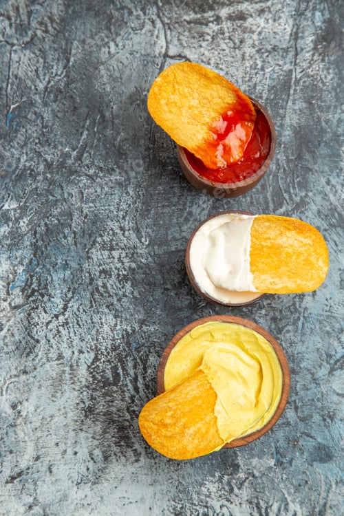 Preview: Vertical view of homemade crispy potato chips ketchup mayonnaise sauce on gray table