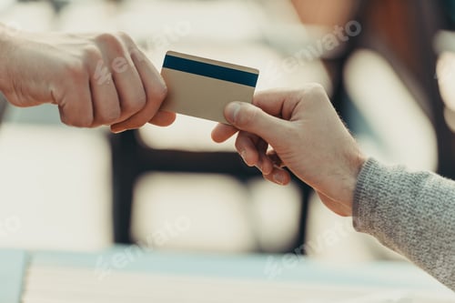 Preview: cropped shot of woman giving credit card to man for purchase