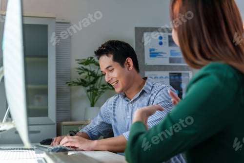 Preview: Asian businesspeople discussing and working together in office using desktop computer