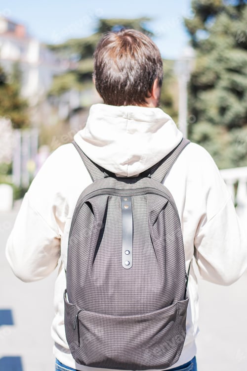 Preview: A male tourist walks around the city view from behind