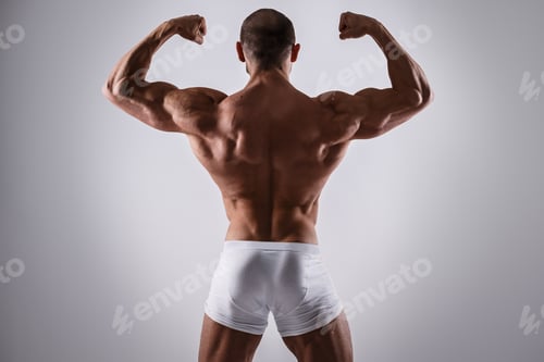 Preview: Handsome muscular man in underwear posing on gray background