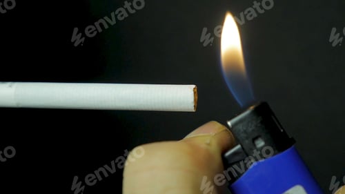 Preview: Hand lighting lighter cigarette closeup. Burning cigarette on black background. Cigarette closeup on