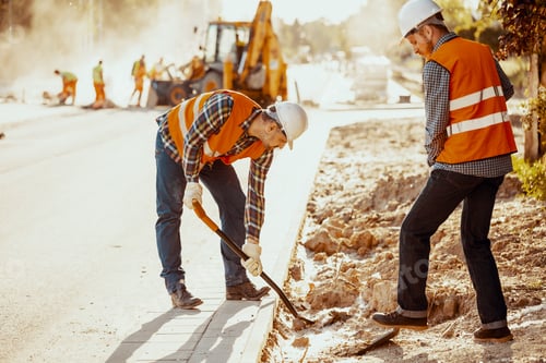 Preview: Workers in reflective vests using shovels during carriageway wor