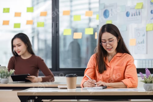 Preview: Businesswomen Collaborating and Sharing Ideas in a Modern Office Environment with Charts and Sticky