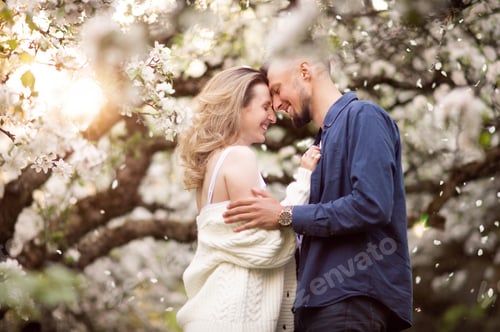 Preview: A young guy looks at his girlfriend and smiles. Petals are flying. Contour light