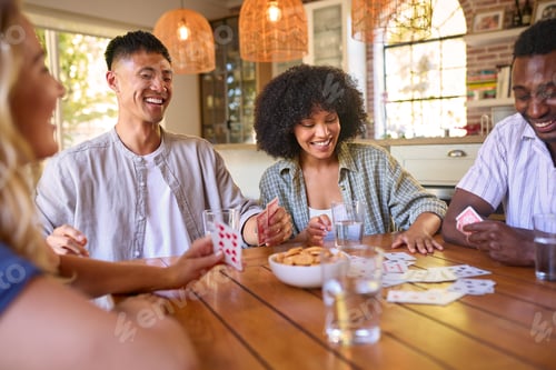 Preview: Group Of Multi-Racial Friends Sitting Around Table Playing Game Of Cards At Home Together